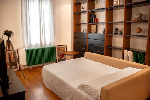 Un dormitorio con una cama y una estantería. en Entire Industrial Flat Venice with Patio - Free Parking, en Mestre