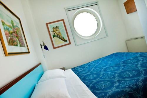 a bedroom with a blue bed and a window at Residence Oltremare in San Benedetto del Tronto