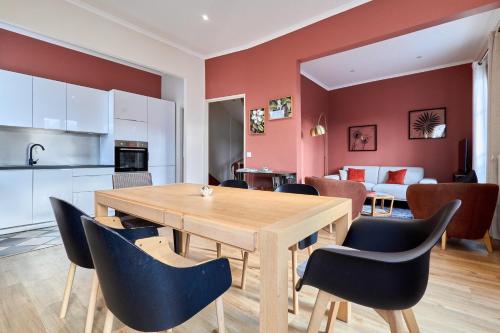 une cuisine et une salle à manger avec une table et des chaises en bois dans l'établissement L'Élégante Demeure Cathédrale Parking gratuit, à Reims