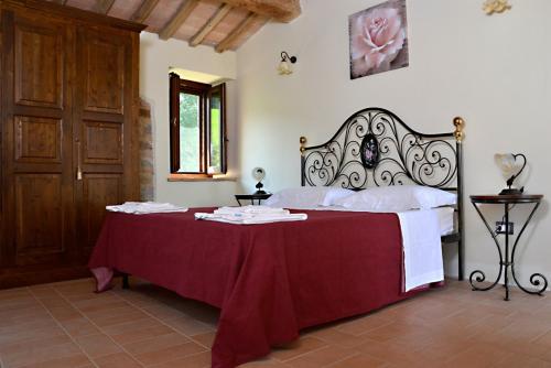 a bedroom with a large bed with a red blanket at Casale di Gualdo in Gualdo di Macerata