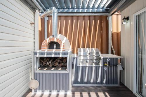 a outdoor grill with a pizza oven in a building at Aotearoa House Yomitan, BBQ, Pizza Oven in Yomitan