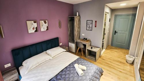 a bedroom with a bed and a purple wall at Daisy Rooms City Centre in Tirana