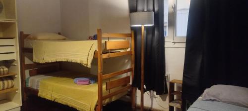 a bedroom with two bunk beds and a lamp at Casa del arbol hostel in Concepción del Uruguay