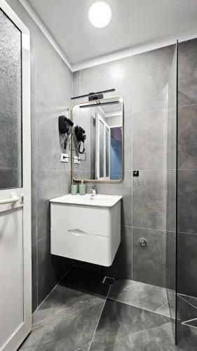 a bathroom with a sink and a mirror at Daisy Rooms City Centre in Tirana