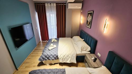 a small bedroom with a bed and a table at Daisy Rooms City Centre in Tirana