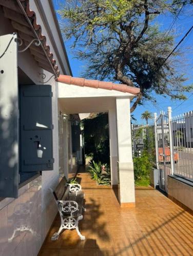 a porch with a bench on a house at Casa del arbol hostel in Concepción del Uruguay