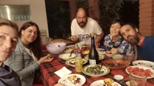 a group of people sitting around a table with food at Casa del arbol hostel in Concepción del Uruguay