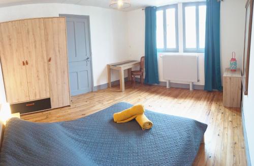 a bedroom with a bed with a yellow towel on it at La Maison du Livradois in Beurrières