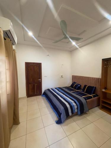 コトヌーにあるHit appartement meublé Fidjrosseのベッドと天井扇風機のある寝室