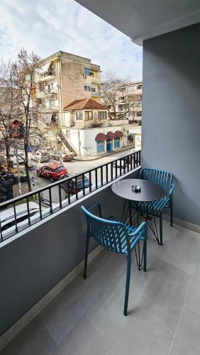 a table and chairs on a balcony with a view at Daisy Rooms City Centre in Tirana