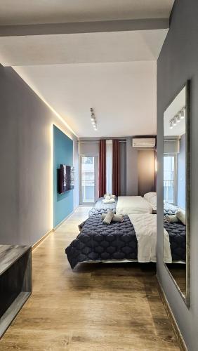 a bedroom with a large bed and a mirror at Daisy Rooms City Centre in Tirana