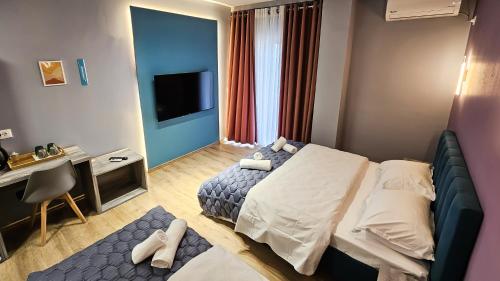 a bedroom with a bed and a desk and a television at Daisy Rooms City Centre in Tirana