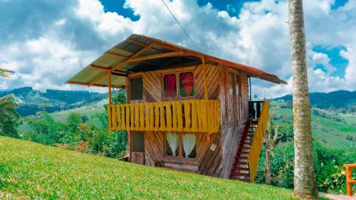 a small wooden house on top of a hill at Cabañas/glamping monaco in Santa Rosa de Cabal