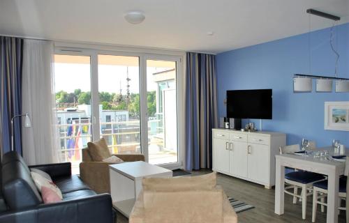 a living room with a couch and a table and a tv at Apartment 29 "Heimathafen 29", Apartmenthaus Hafenspitze, Blickrichtung InnenstadtBinnenhafen in Eckernförde