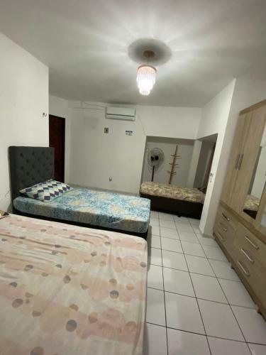 a large room with two beds and a mirror at Casa Em Pirangi Praia - RN in Parnamirim