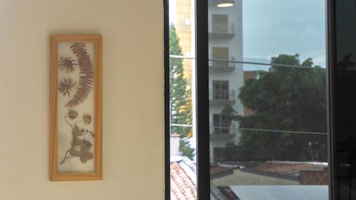 a picture of a flower on a wall next to a window at Selva House in Medellín
