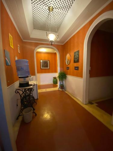 un pasillo con paredes de color naranja y TV en una mesa en Villa Aruanda, en Petrópolis