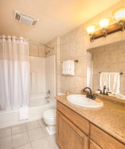 a bathroom with a sink and a tub and a toilet at Elk Refuge Inn in Jackson