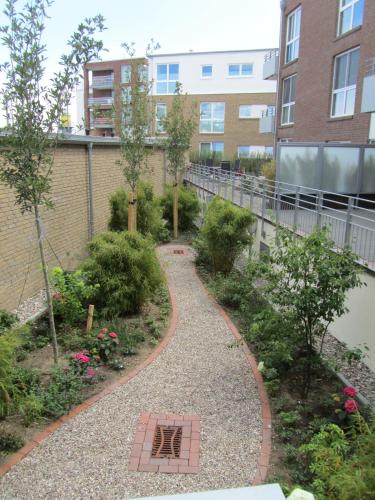 a garden with a walkway in front of a building at Ferienwohnung "Silbermöwe II", Hafenspitze Quartier in Eckernförde