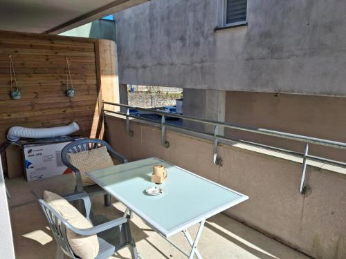 une table et des chaises sur le balcon d'un bâtiment dans l'établissement Le plaisir du calme, à Limoges