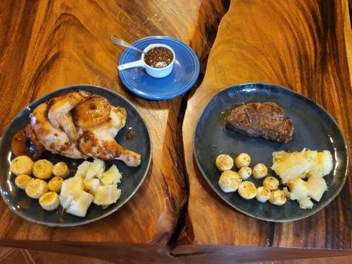 two plates of food with meat and potatoes on a table at Hacienda en Los Volcanes in Hacienda Guayabo