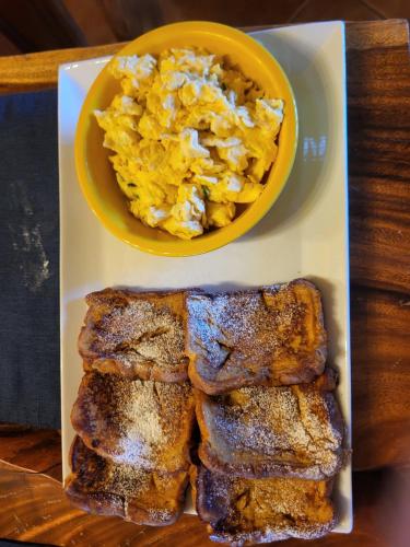 a plate of breakfast food with a bowl of scrambled eggs at Hacienda en Los Volcanes in Hacienda Guayabo