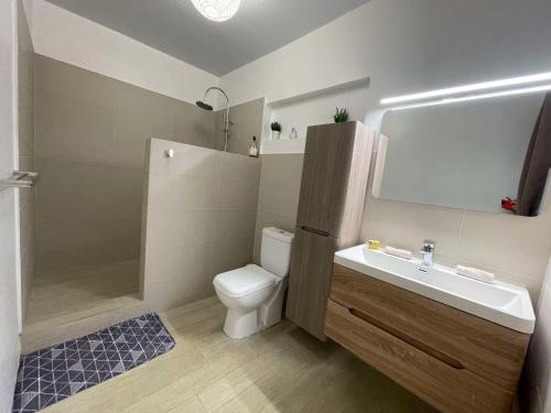 a bathroom with a toilet and a sink and a shower at Bora Bora Fare Sophia in Bora Bora