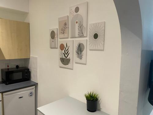 a kitchen with some pictures on a wall at Cosy 2 bed Wimbledon Apartment in Raynes Park