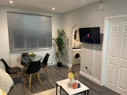 a living room with a couch and a table at Cosy 2 bed Wimbledon Apartment in Raynes Park