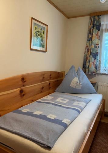 a bedroom with a wooden bed with a blue comforter at Ferienwohnung Burgblick in Sörg