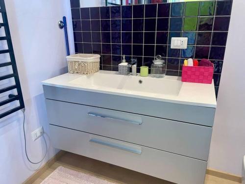 La salle de bains est pourvue d'un lavabo et d'un mur carrelé noir. dans l'établissement Apartment in Juan-les-Pins near Sandy Beaches, à Antibes