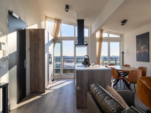 a kitchen and living room with a large window at Penthouse in Sint-Annaland by the Beach in Sint Annaland