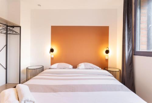 une chambre avec un lit avec un mur orange dans l'établissement Cozy - 3 Chambres - Netflix - Kitchenette - Le Montesquieu, à Roubaix