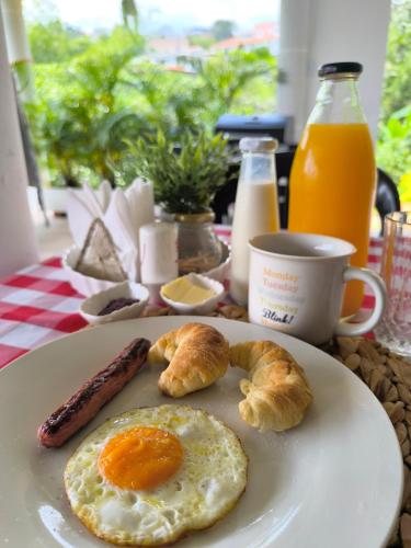 een bord met eieren worst en croissants op tafel bij Casa Yarumo Campestre in Meléndez Arriba