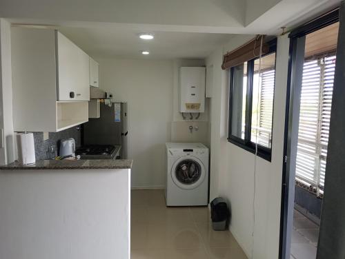 a kitchen with a washing machine in a room at Dpto zona pelegrini 1 dormitorio cochera opc in Rosario