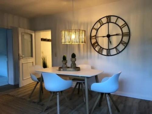 a dining room with a table and a large clock at Fewo 3 in Nortorf