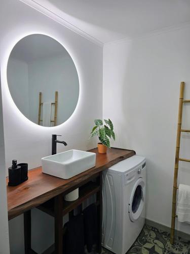 a bathroom with a sink and a washing machine at HOME4U in Horta