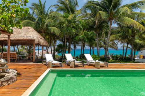 a resort with a pool and chairs and the ocean at Casa Vista al Mar Isla Mujeres in Isla Mujeres