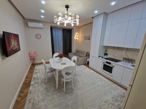 a kitchen and dining room with a white table and chairs at Новый ЖК Capital City, элитная квартира in Shymkent