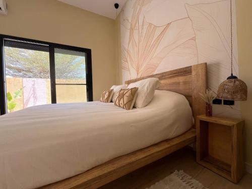 a bedroom with a bed with pillows and a window at EMZ House in Saly Niakh-Niakhal