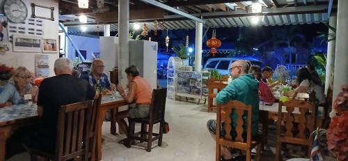 un groupe de personnes assises à des tables dans un restaurant dans l'établissement Thai Garden​ Resort​ Kanchanaburi​, à Kanchanaburi