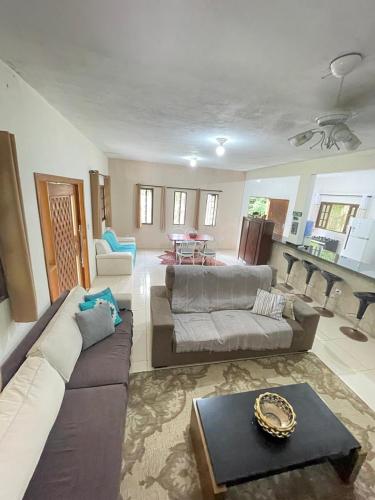 a living room with a couch and a table at Chácara Gomes - Caiubura - Bertioga in Bertioga