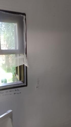 a window in a room with a white wall at SUITES E CHALES PRIVADOS Rock's&Rose's home in Camburi