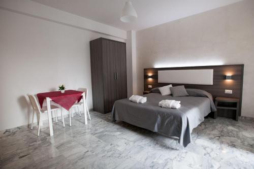 ローマにあるB&B Momenti Romaniのベッドルーム1室(ベッド1台、テーブル、赤い椅子付)