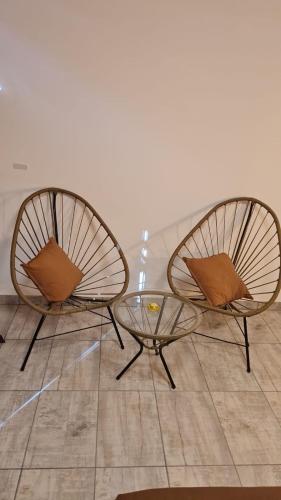 two chairs and a glass table in a room at Brisas Rumipal dúplex premium Villa Rumipal in Villa Rumipal
