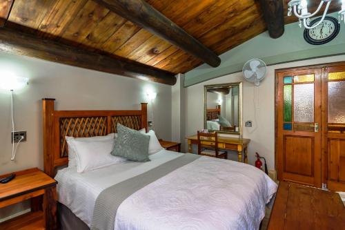 a bedroom with a large bed and a wooden ceiling at Togryersvlei Venue & Guest House in Jacobs Bay