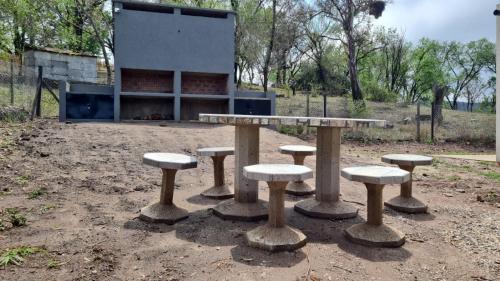 a group of tables and stools in front of a building at Brisas Rumipal dúplex premium Villa Rumipal in Villa Rumipal