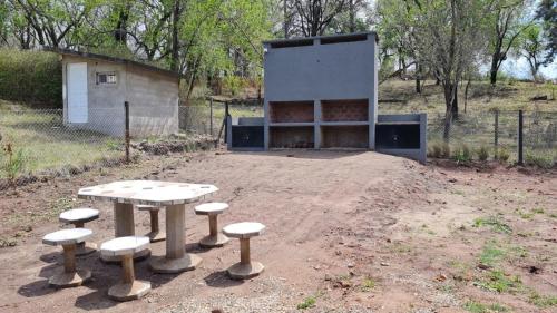 a picnic table and stools in front of a building at Brisas Rumipal dúplex premium Villa Rumipal in Villa Rumipal