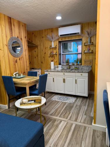 a kitchen and dining room with a table and blue chairs at La Mia Casa II in Sarasota
