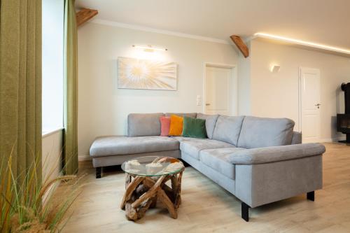 a living room with a couch and a table at Osterhof Fehmarn - Casa Florale in Fehmarn